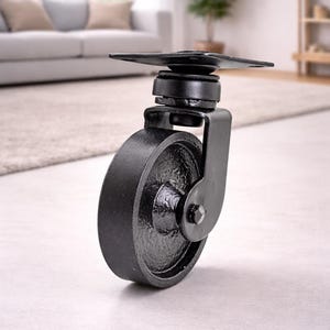 May include: A black caster wheel with a mounting plate, suitable for furniture. The wheel is approximately 10 cm in diameter. The design features a sturdy, industrial aesthetic, suitable for various applications.