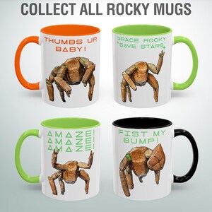 May include: Four white ceramic mugs with colorful handles and interiors. Each mug features a unique illustration of a brown, rock-like creature with different poses and phrases like "Thumbs Up, Baby!" and "Fist My Bump!" The text "Collect All Rocky Mugs" is at the top.