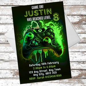 May include: A green and black video game controller with a neon green glow. The text "GAME ON! JUSTIN HAS REACHED LEVEL 8" is at the top of the invitation. The invitation also includes the date, time, and location of the party.