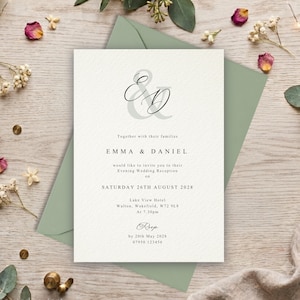 May include: A white wedding reception invitation card with black serif text and a large grey ampersand monogram. The text reads: Together with their families, EMMA & DANIEL, would like to invite you to their Evening Wedding Reception on SATURDAY 26TH AUGUST 2028, Lake View Hotel, Walton, Wakefield, W72 9L8, At 7.30pm, RSVP by 20th May 2028, 07950 123456.