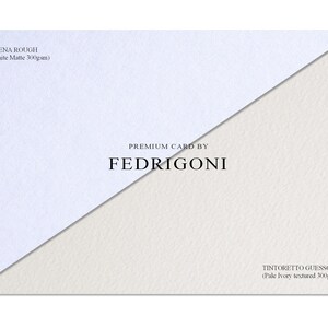 May include: A rectangular display of two premium card stocks by Fedrigoni. The top left section is white matte Arena Rough 300gsm paper. The bottom right section is pale ivory textured Tintoretto Gesso 300gsm paper. The text reads Premium Card By Fedrigoni.