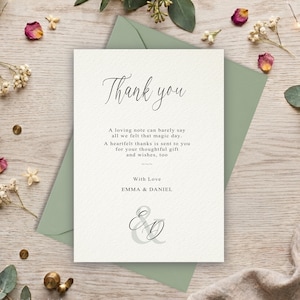 May include: A white thank you card with black text that reads Thank you, A loving note can barely say all we felt that magic day. A heartfelt thanks is sent to you for your thoughtful gift and wishes, too, With Love EMMA & DANIEL, and E&D.