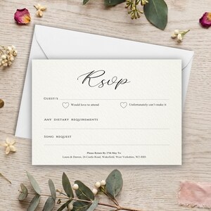 May include: A cream-coloured RSVP card with black text and a white envelope. The card features the word RSVP in script, lines for guest names, checkboxes with hearts for attendance, and sections for dietary requirements and song requests.