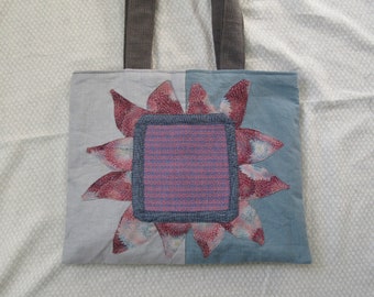 Appliqued floral tote with hand woven focal point, magnetic snap closure, multiple pockets, 20"hx20"w