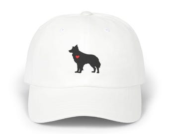 May include: White baseball cap with a black dog silhouette and a red heart. The cap has a curved peak and an adjustable strap. A fashionable accessory for dog enthusiasts.