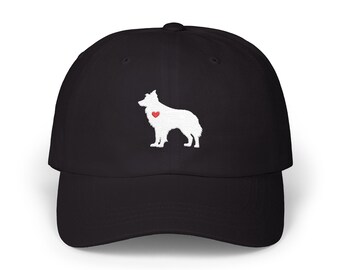 May include: Black baseball cap with a white dog silhouette and a red heart. The cap has a curved peak and a structured design. The dog illustration is on the front, providing a simple, stylish appearance. The cap is a popular accessory.