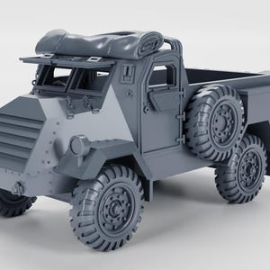 Puede incluir: Modelo gris de un camión blindado con una caja de carga, neumáticos de repuesto y una parte superior cubierta de lona. El vehículo tiene una estética militar, con una parte delantera inclinada, faros y un diseño detallado de las ruedas. El modelo está sobre un fondo liso.