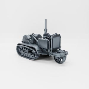 May include: A gray metal model of a tracked tractor with a single front wheel. The tractor has a large engine and a tall exhaust pipe.