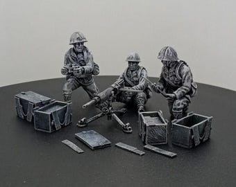 Könnte beinhalten: Miniatur-Graufiguren von Soldaten, die ein Maschinengewehr bedienen, mit Munitionskisten und Zubehör. Die Szene zeigt drei Soldaten mit Helmen, von denen einer an der Waffe kniet und zwei andere Vorräte handhaben. Ein detailliertes Modell.