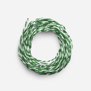 May include: A roll of green and white baker's twine. The twine is wound into a circle.