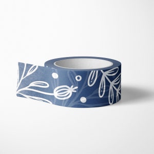 May include: A roll of blue washi tape with a white floral pattern. The tape has a white background with a blue ombre effect and white floral designs.