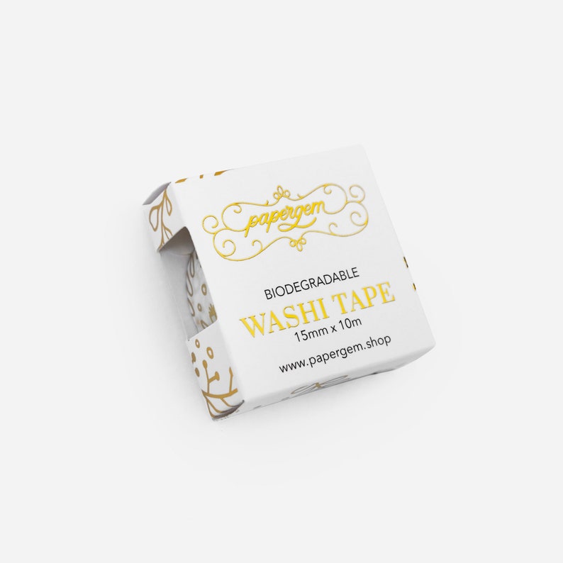May include: A white box with gold lettering and a floral design. The box contains a roll of biodegradable washi tape. The text on the box reads "papergem", "Biodegradable Washi Tape", "15mm x 10m", and "www.papergem.shop".