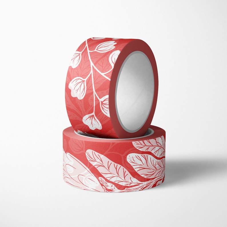 May include: Two rolls of red washi tape with a white floral pattern. The tape is rolled up and the ends are visible.