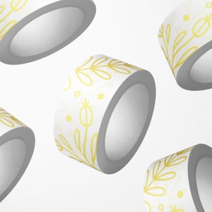 May include: Four rolls of white washi tape with a gold floral pattern. The tape is rolled up and the ends are visible.
