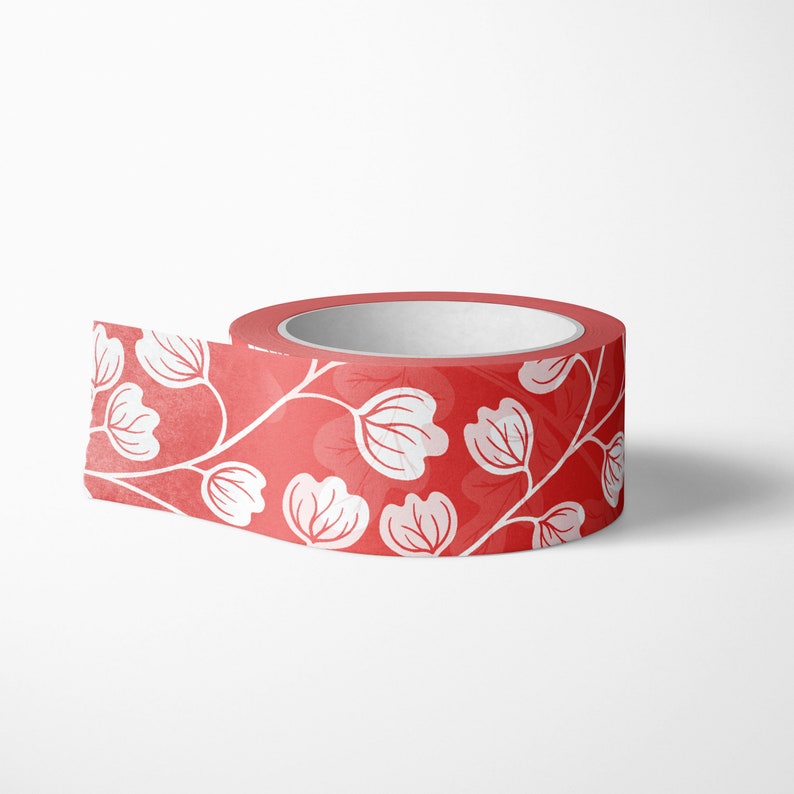 May include: A roll of red washi tape with a white floral pattern. The tape is partially unrolled, revealing the design.