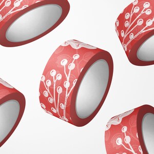 May include: Four rolls of red washi tape with a white floral pattern. The tape is decorated with white berries and branches.
