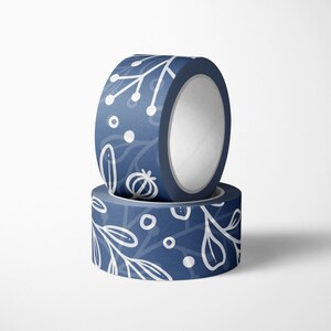 May include: Two rolls of blue washi tape with a white floral pattern. The tape is decorated with white dots and lines.