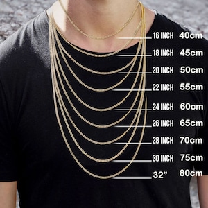 May include: A person wearing a black t-shirt with multiple gold-colored chain necklaces of varying lengths. The image includes text indicating the chain lengths in inches and centimeters: 16 inch (40cm) to 32 inch (80cm).