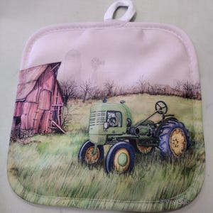 May include: A green and blue tractor with a red barn in the background. The tractor is on a field of green grass. The image is on a white pot holder with a white loop handle.