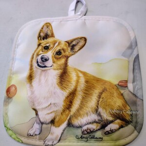 May include: A white pot holder with a watercolor illustration of a brown and white corgi dog. The dog is sitting and looking to the left. The text "Amy Callaway" is printed in the bottom right corner.