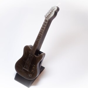 May include: A black electric guitar shaped birthday candle with a white wick.