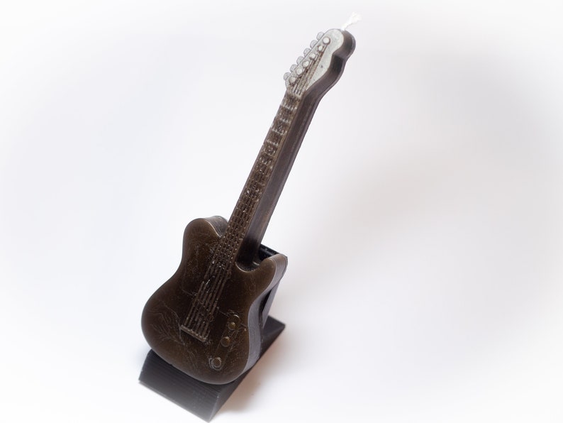 May include: A black electric guitar shaped birthday candle with a white wick.