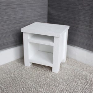 Peut inclure: Chevet en bois blanc avec une seule étagère. Le chevet a un design simple avec des lignes épurées.
