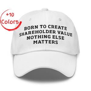 May include: White baseball cap with the text "BORN TO CREATE SHAREHOLDER VALUE NOTHING ELSE MATTERS" in black. A red circle with the words "+10 Colors" is in the upper left corner. The cap has a curved brim and a button on top.
