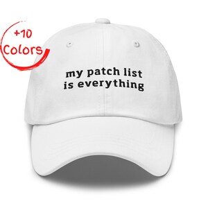 May include: White baseball cap with the embroidered text "my patch list is everything" in black. The cap has a curved brim and a button on top. A red circle with the words "+10 Colors" is in the upper left corner.