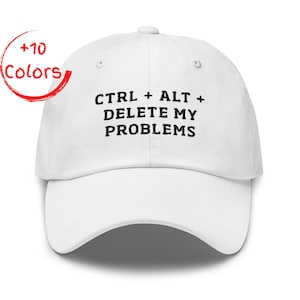 Può includere: Cappellino da baseball bianco con la scritta "CTRL + ALT + DELETE MY PROBLEMS" in nero. Un cerchio rosso con "+10 Colors" è in alto a sinistra. Il cappellino ha una visiera curva e un bottone in cima.