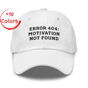 Könnte beinhalten: Weiße Baseballkappe mit dem Text "ERROR 404: MOTIVATION NOT FOUND" in Schwarz. Die Kappe hat einen gebogenen Schirm und einen Knopf oben. Ein roter Kreis mit "+10 Colors" befindet sich in der oberen linken Ecke.