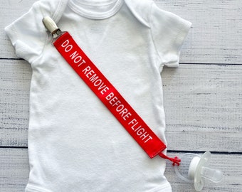 Prendedor de chupeta para bebês da Aviation: "Não remova antes do voo"