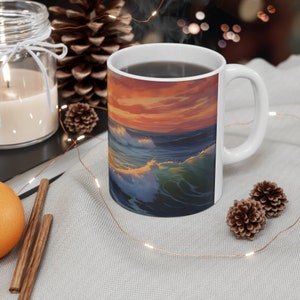 May include: White ceramic mug with a colorful sunset and ocean wave design. The mug is filled with coffee and steam is rising from the top.