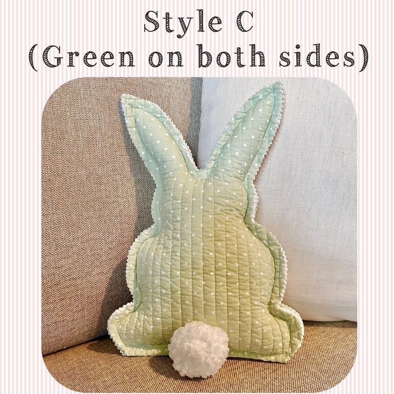 May include: A light green bunny-shaped pillow with white polka dots and a white pom-pom tail. The pillow has a scalloped edge and the text "Style C (Green on both sides)". The pillow is on a neutral-colored surface.