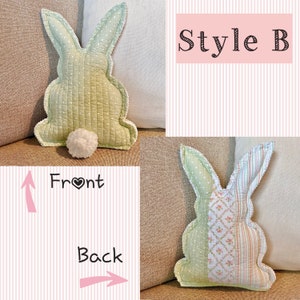 May include: A light green bunny-shaped pillow with a white pom-pom tail. The pillow has a quilted design and white polka dots on the ears. The text "Style B" is in a pink box. The front and back of the pillow are labeled.