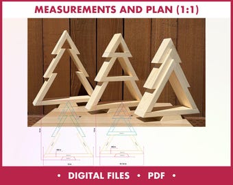 May include: Three unfinished wooden Christmas tree decorations with a diagram of measurements and plans. The trees are made of light-colored wood and are displayed on a wooden surface. The diagram includes measurements in inches. The text "MEASUREMENTS AND PLAN (1:1)" is at the top.