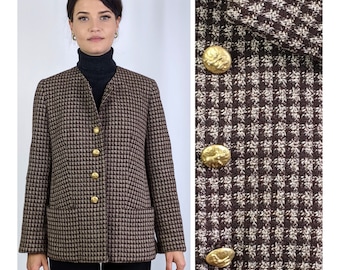 Könnte beinhalten: Ein brauner und weißer Hahnentritt-Blazer mit goldenen Knöpfen. Der Blazer hat einen Kragen und lange Ärmel.