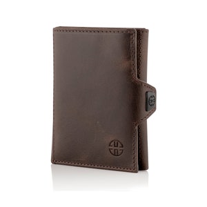 May include: A brown leather wallet with a flap closure and a small metal logo on the front. The wallet is folded in half and has a stitched edge.