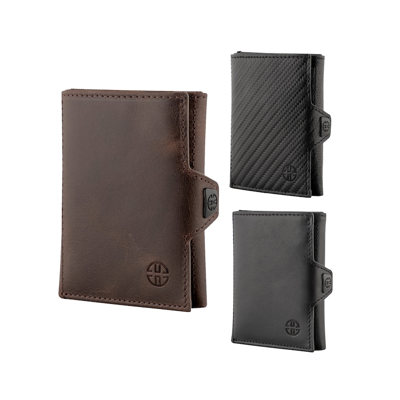 May include: Three different styles of wallets. One is brown leather, one is black leather, and one is black with a carbon fiber pattern. All three wallets have a small metal logo on the front.