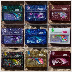 May include: Nine different resin trinket dishes with a rainbow, clouds, and stars design. Each dish has a different color background and glitter. The text "Trapper Keeper" is printed on each dish.