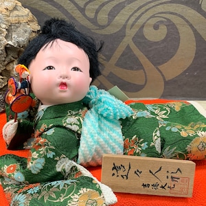 Beautiful porcelain doll - Japanese doll lying on a bright orange cushion - mint condition - DVSPOP