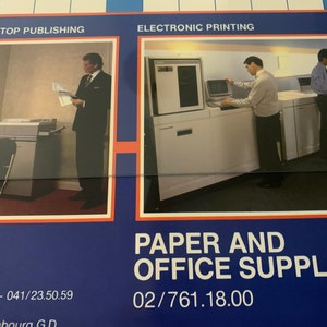 May include: Two images showing office equipment. The first image shows a man standing in an office with a copier. The second image shows three people in an office with a large printer. The text on the image reads "TER: DESKTOP PUBLISHING", "ELECTRONIC PRINTING", "PAPER AND OFFICE SUPPLIES", "000 Liège - 041/23.50.59", "333 Luxembourg GD", and "02/761.18.00".