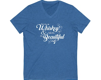 May include: A blue V-neck t-shirt with the text "Give me Whiskey & tell me I'm Beautiful" in white cursive font with decorative flourishes.