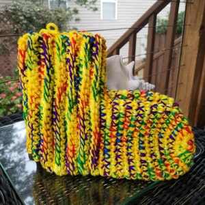 May include: A pair of yellow crochet slippers with multi-colored stripes. The slippers are made with a chunky yarn and have a soft, cozy look.