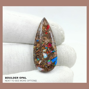May include: A teardrop-shaped boulder opal cabochon with a brown matrix and iridescent flashes of blue, green, red, and gold. BOULDER OPAL NEXT TO SEE MORE OPTIONS
