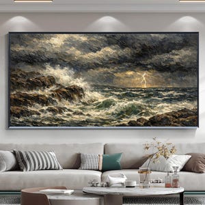 Può includere: Dipinto incorniciato di un paesaggio marino tempestoso con onde che si infrangono e un fulmine. L'opera presenta nuvole scure e drammatiche e scogliere rocciose, con sfumature di grigio, marrone e bianco. Il dipinto è esposto sopra un moderno divano.