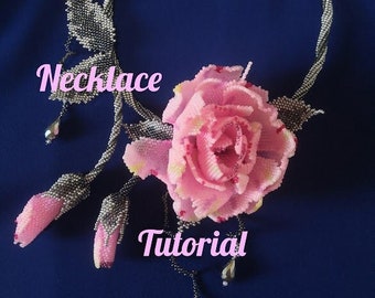May include: A beaded necklace with a pink rose and two buds. The necklace is made of silver and black beads and has a pink and white rose with a green stem. The text "Necklace Tutorial" is written on the image.