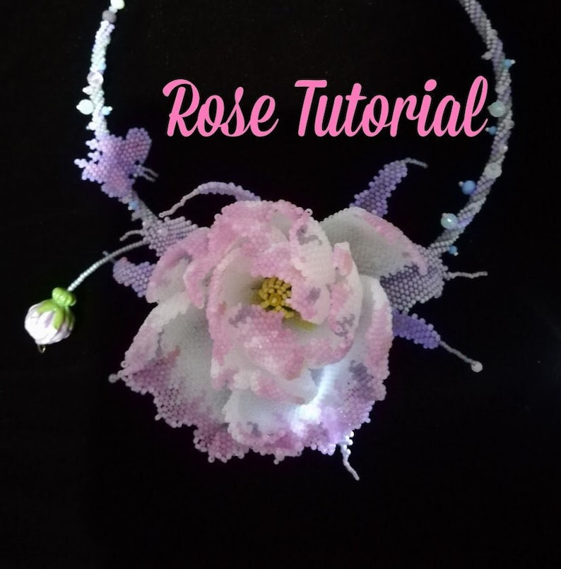 May include: A beaded necklace with a large pink and white rose flower pendant. The necklace is made with small beads in shades of purple, blue, and white. The text "Rose Tutorial" is written in pink letters on the image.