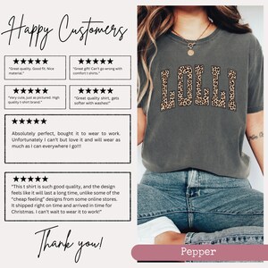 May include: A gray t-shirt with the word "LOLLI" printed in brown and black leopard print letters. The shirt is shown on a model wearing blue jeans. Customer reviews are shown below the image, praising the quality and fit of the shirt.