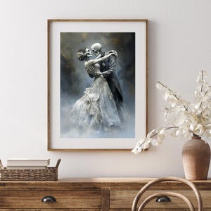 May include: Framed art print featuring a skeletal couple embracing in a romantic pose. The artwork depicts a man in a dark coat and a woman in a flowing white dress. The background has a misty, ethereal quality.